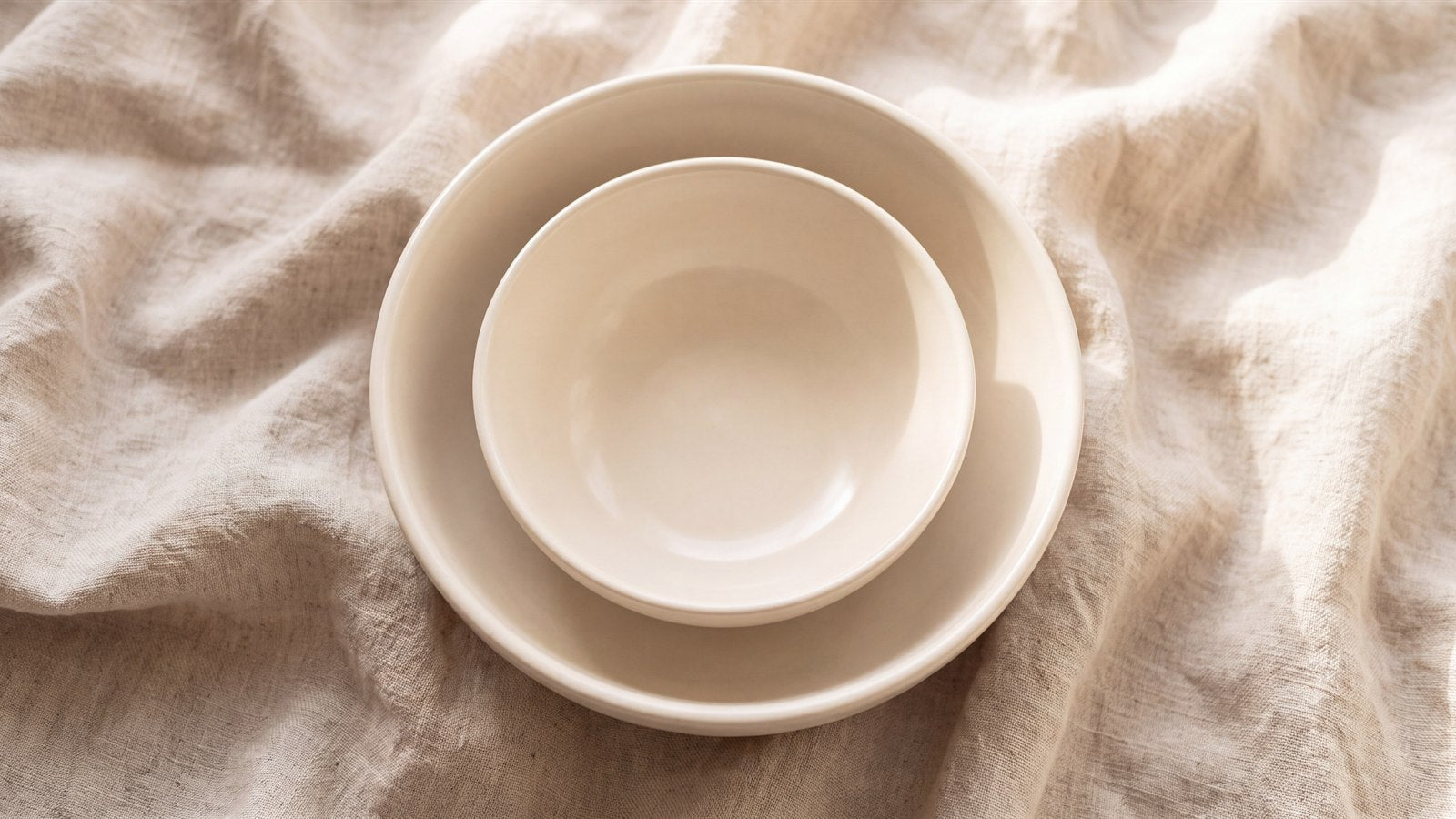 Two nested ceramic bowls, one resting inside the other, both empty