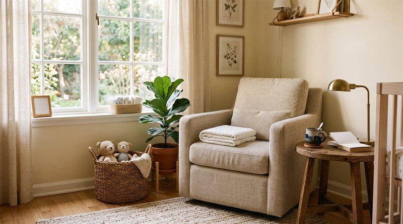 A quiet corner of a nursery in morning light, with an armchair, folded blankets and a basket of soft toys